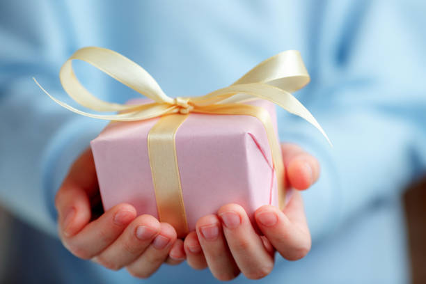 istock Child Holding a Gift Box On a Blue Background 1291629840