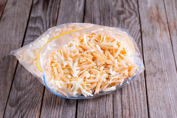 Frozen grated cheese in a package on the table Frozen grated cheese in a bag shredded mozzarella stock pictures, royalty-free photos & images