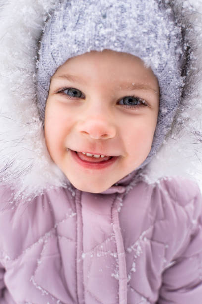 porträt eines schönen kleinen mädchens 4 jahre alt in winterkleidung im freien - child winter snow 4 5 years stock-fotos und bilder