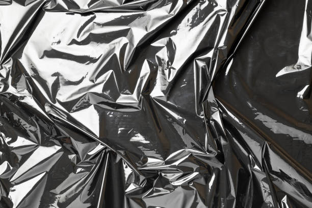 istock Smooth texture. Black shiny film bag pattern. Wrap transparent dark cellophane background. Real texture of polyethylene foil. 1291634062