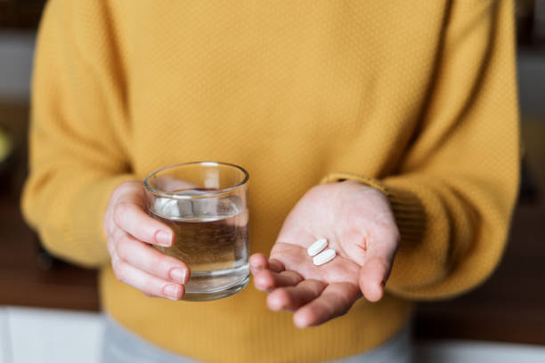 istock Young woman holding white pills in hands 1291635065
