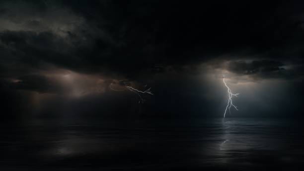 istock Monsoon Cyclone Storm Clouds with Multiple Lightnings above Dark Night Tropical Ocean 1291635343
