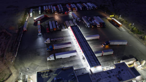 Birds Eye View of Trucks Refueling at Rest Stop at Night Top down aerial shot of a truck stop on I-10 freeway near Salome, AZ. gas station photos stock pictures, royalty-free photos & images