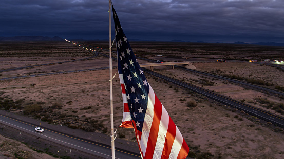 Aerial ahot of a US flag waving over a freeway at a truck stop near Salome in Arizona.