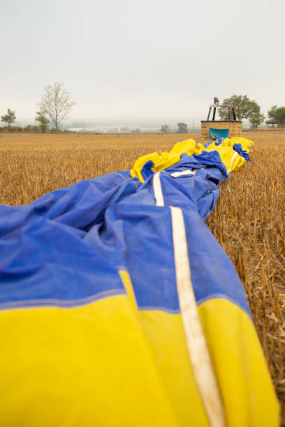 Hot air balloon deflated in a cropped field