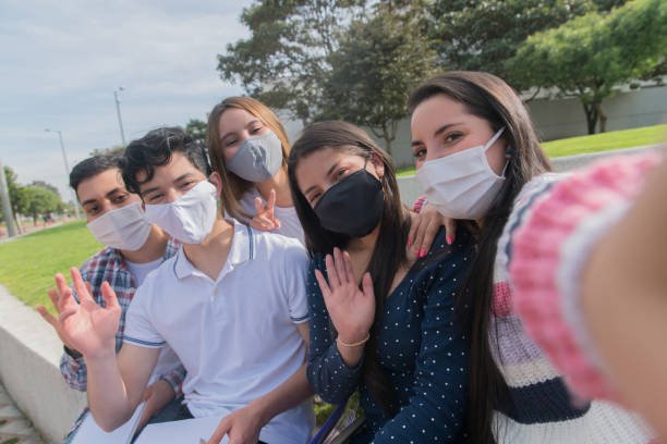 istock Group of students taking a selfie at school wearing facemasks 1291638077