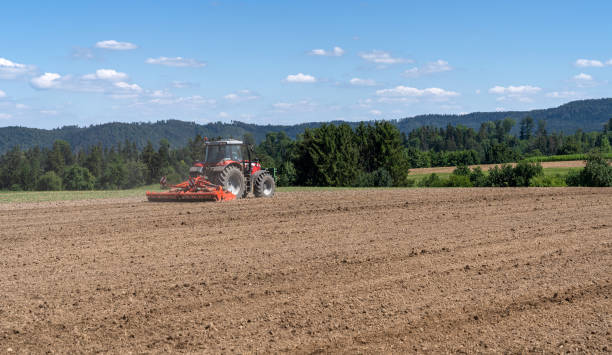 istock Tractor while harrowing the brown earth in a field 1291638550
