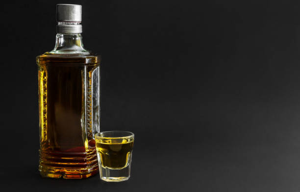 bottle of vodka with small glasses on black background. space for text. - whisky liqueur glass alcohol bottle imagens e fotografias de stock