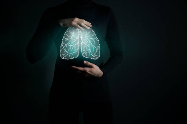 Illustration of lungs detox with highlighted organ and contrast hands on dark background. Low key photo with copy space toned in dark green colors. oncology photos stock pictures, royalty-free photos & images