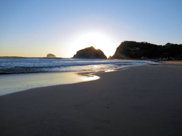 istock Sunset behind rock formations on the beach 1291643362