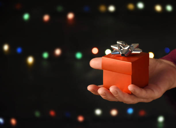 istock Female hand giving a red gift box 1291644386