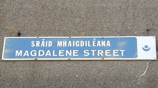 Magdalene Street street sign in English and translated directly into the Irish language. Situated in Drogheda town centre, County Louth, Ireland.