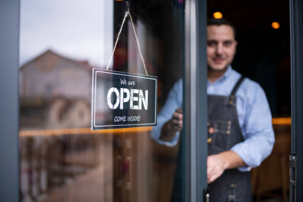 istock Coffee owner opening and welcome his customers. 1291646006
