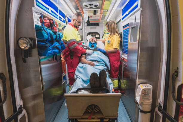 a medical team in an ambulance helps an adult man stock photo