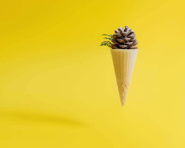 istock Pine cone in ice cream cone on yellow background 1291654170