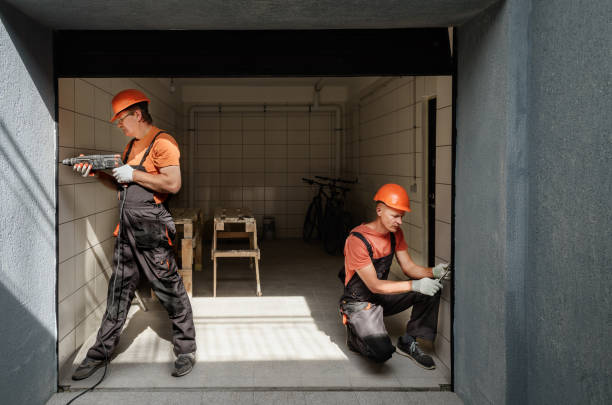 The workers are installing lift gate in the garage.