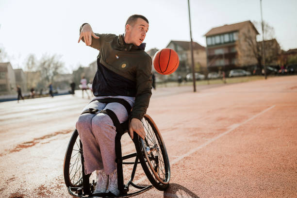 istock Man in wheelchair playing basketball 1291655573