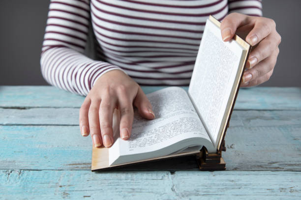 istock woman hand Holy Bible on the table 1291655713