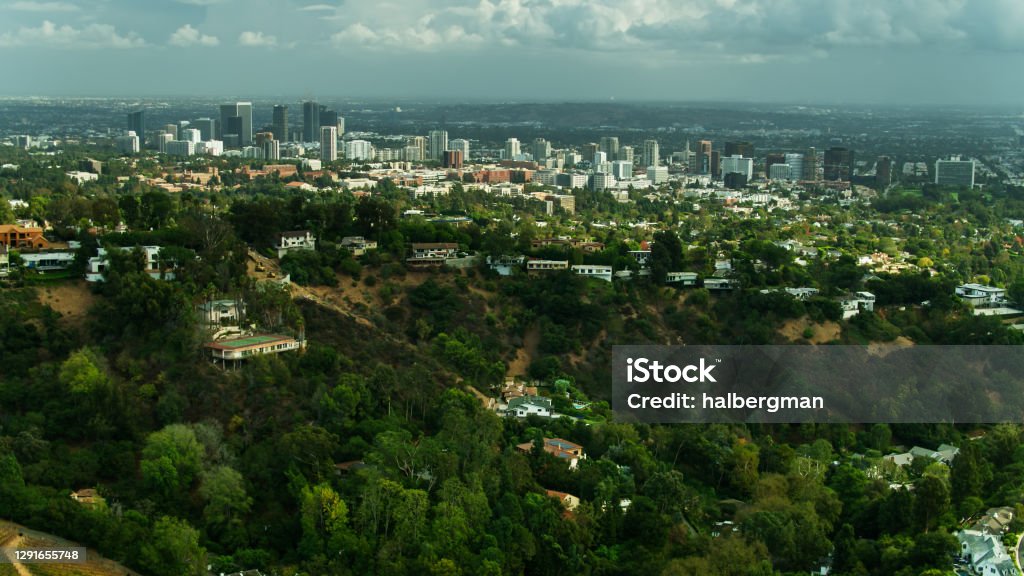 Drone Shot of Houses in Bel Air with Century City and Wilshire Corridor Beyond Aerial establishing shot of the Sepulveda Pass in Los Angeles, which connects the west side of the Los Angeles Basin to the San Fernando Valley through the Santa Monica Mountains. Bel Air Stock Photo