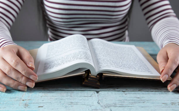 istock woman hand Holy Bible on the table 1291655944