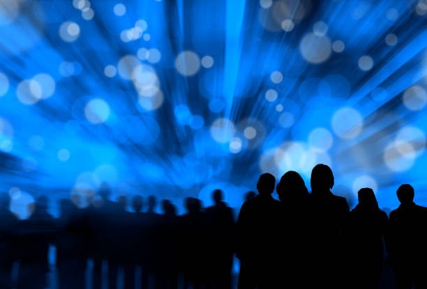 istock Silhouetted group of people over abstract lights 1291658046
