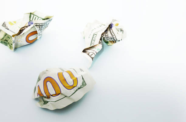 istock Crumpled hundred dollar bills on blue 1291658105