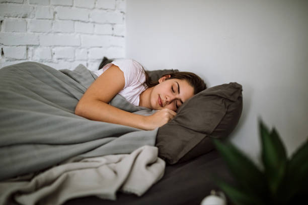 istock Young woman sleeping in bedroom 1291660256