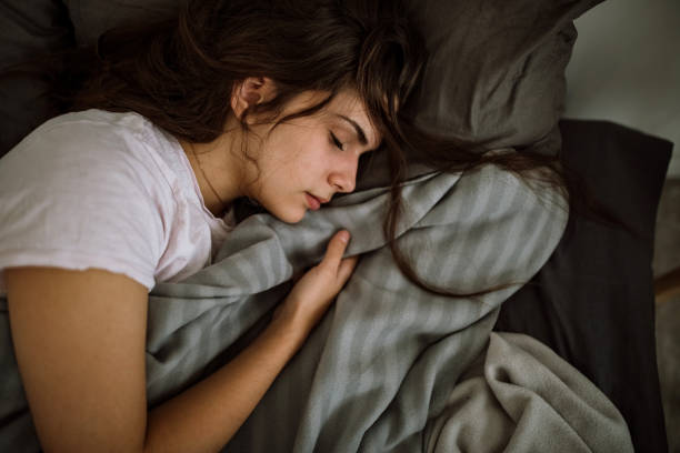 istock Young woman sleeping in bedroom 1291660420