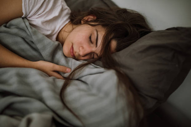 Young woman sleeping in bedroom stock photo