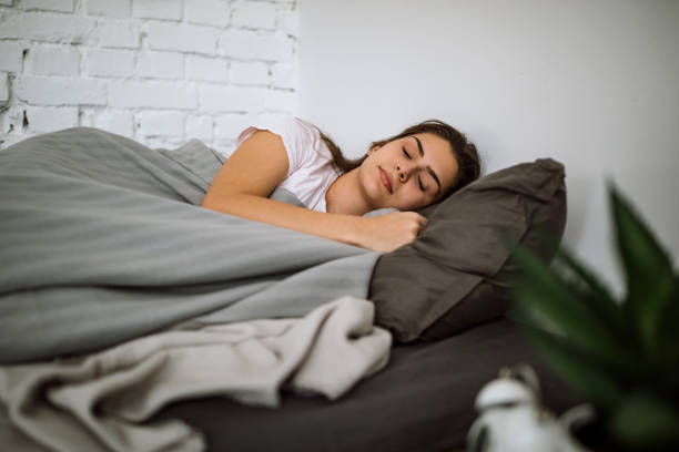 istock Young woman sleeping in bedroom 1291662078