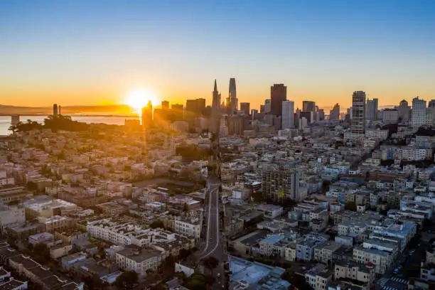 Aerial view at sunrise of Columbus Ave. n San Francisco. Looking towards the skyscrapers of the Financial District. Iconic buildings fill the skyline as the sun comes up behind the city.