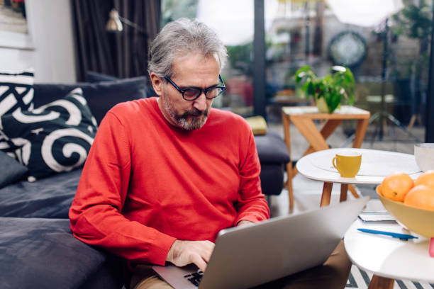 istock Mature entrepreneur sitting on the floor and working from home 1291672039