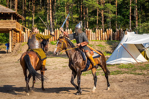Cedynia, Poland June 2019 Historical reenactment of Battle of Cedynia, duel or sword fight, between two knights on horses in front of the wooden fort