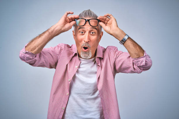 istock Shocked bearded adult man holding his spectacles in studio 1291673555