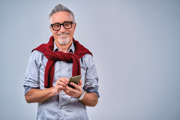 istock Optimistic adult man holding smartphone and looking at camera 1291673565