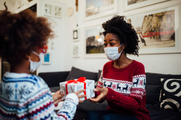 istock Mother and Daughter at home wearing a protective face mask 1291673569