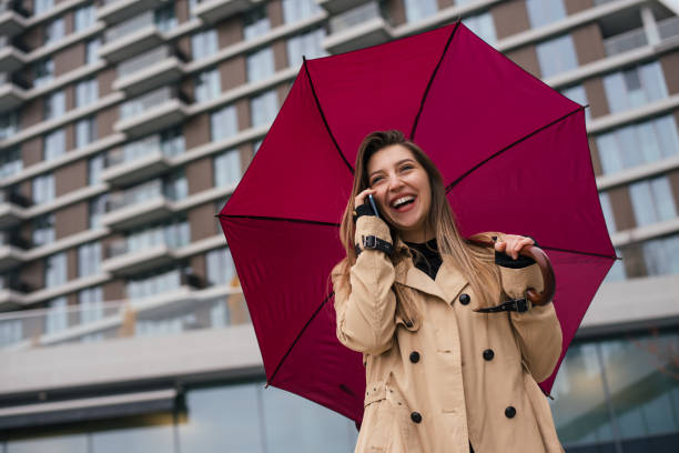 istock Smiling business woman standing under umbrella 1291673626