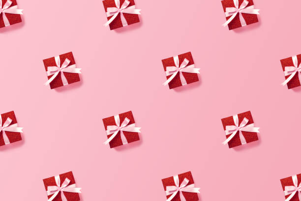 istock Red gift box with pink ribbon on pink background. 1291673727