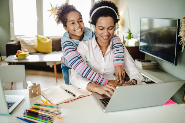istock Mother is working from home and her daughter is embracing her 1291673796