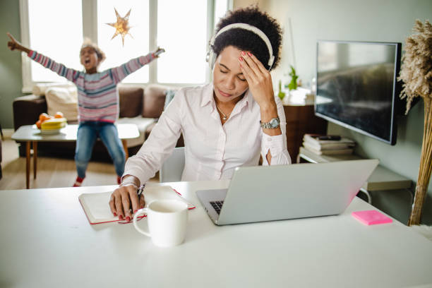 シングルマザーのために自宅で働くことはストレスになる可能性があります - mature adult audio ストックフォトと画像