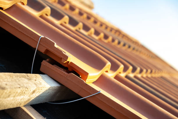 primer plano del anclaje de montaje metálico para la instalación de tejas de cerámica amarilla montadas sobre tablas de madera que cubren el techo del edificio residencial en construcción. - roof batten fotografías e imágenes de stock