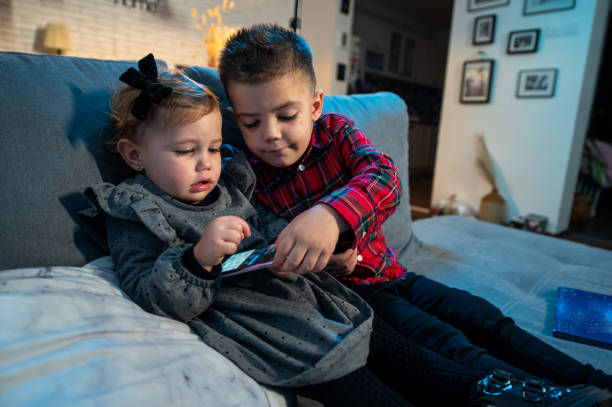 bebé y su hermano en la cama foto de stock - 18 23 meses fotografías e imágenes de stock