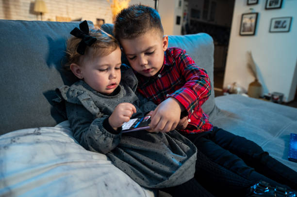 bebé y su hermano en la cama foto de stock - 18 23 meses fotografías e imágenes de stock