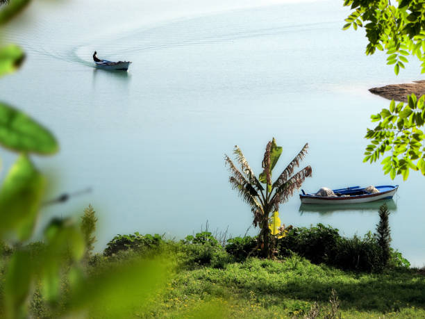 pescatore in piccola barca sul lago - turkish culture turkey fishing boat fishing foto e immagini stock