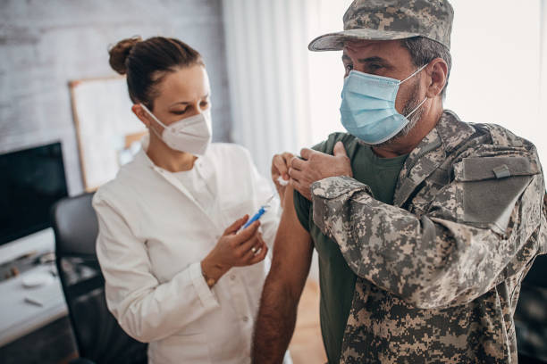 военнослужащий получает быструю вакцину covid-19 в кабинете врача - doctor medical injection female general practitioner стоковые фото и изображения