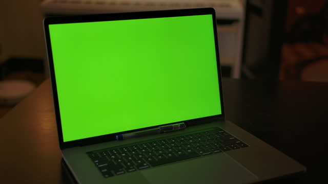 Dolly in shot of green screen laptop indoor of cozy home interior