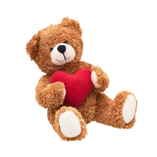 Teddy bear with a red heart isolated over white background. Valentine's Day concept. Soft toy bear
