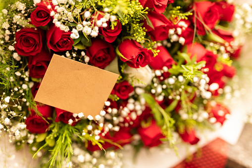 The girl's hand gently touches the flowers in her wedding bouquet of red roses. Wedding bouquet. Selective focus.