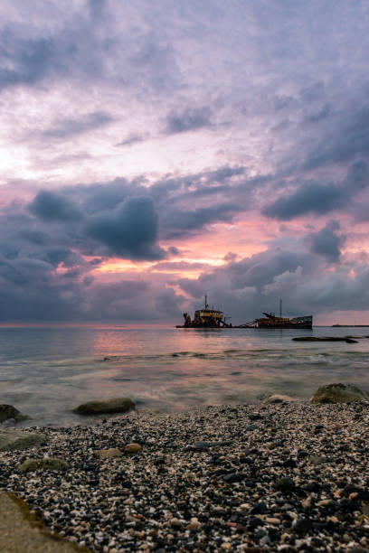 istock Cloudy sunset with a shipwreck on a calm sea at Saint Martin,Antilles 1291683348