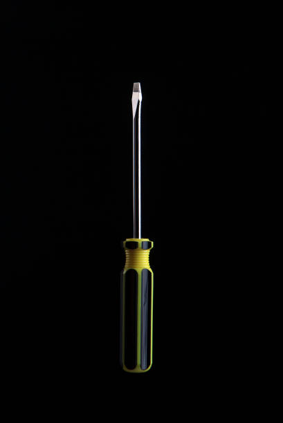cacciavite nero e giallo su sfondo nero - screwdriver isolated phillips work tool foto e immagini stock